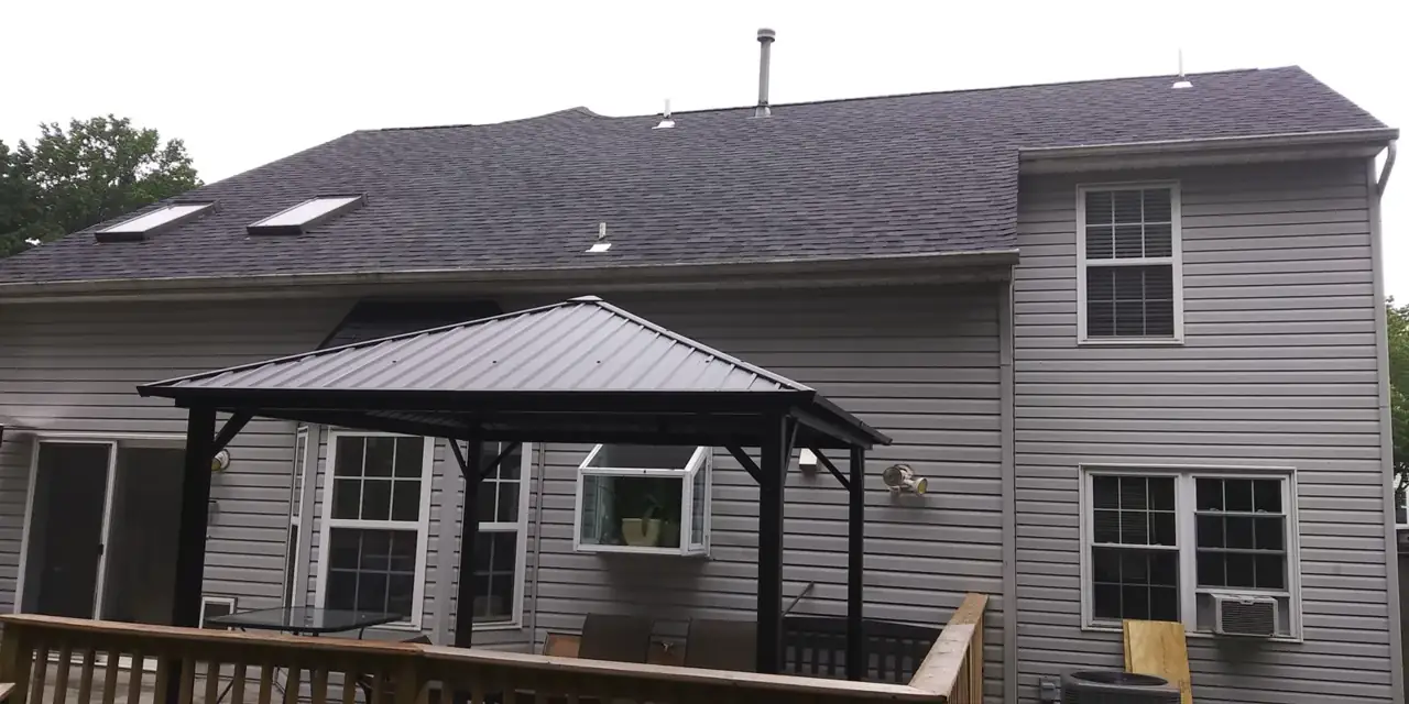 Rear of a home with new roof over a back-deck pavilion