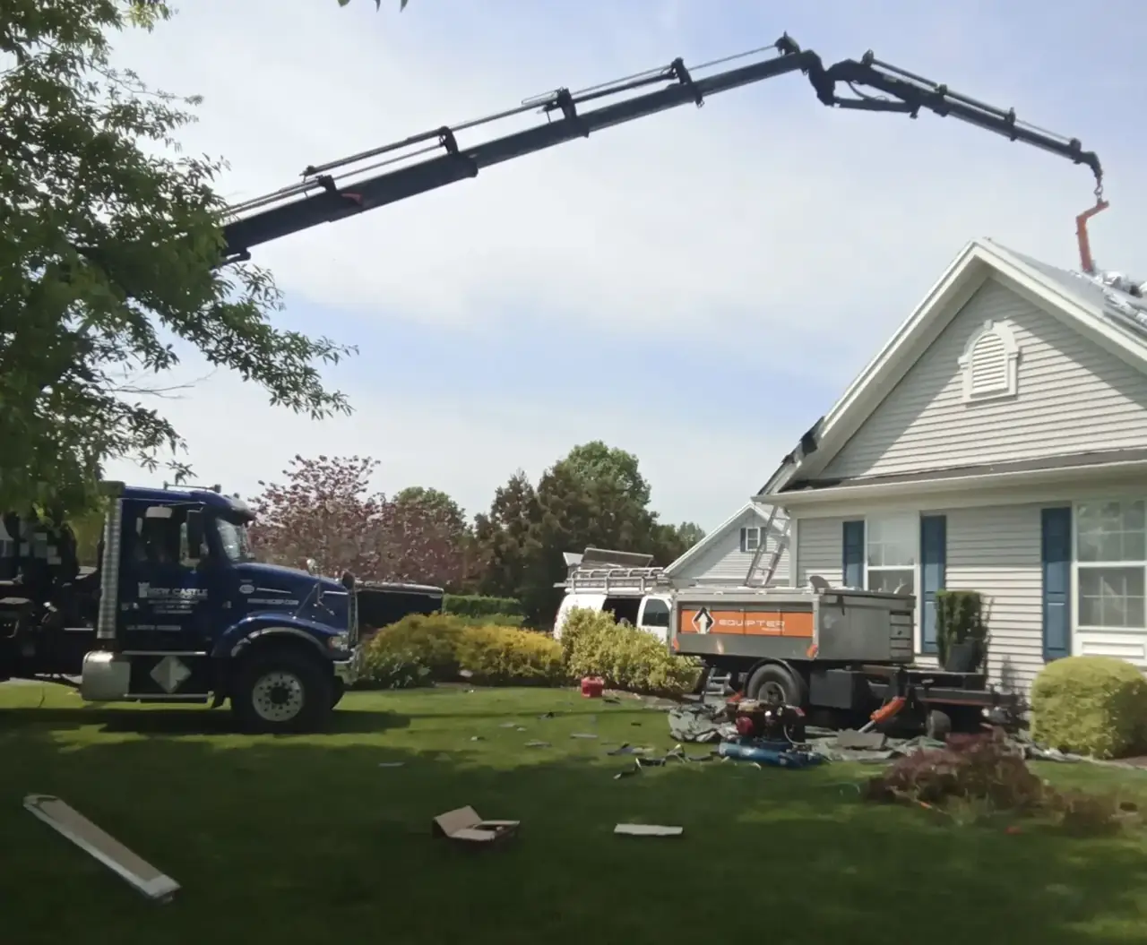 Boom truck delivering shingles to a roof replacement job