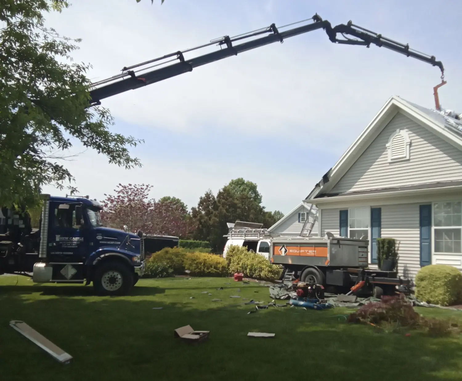 Crane truck delivering roofing materials to an Allabaugh Construction job site