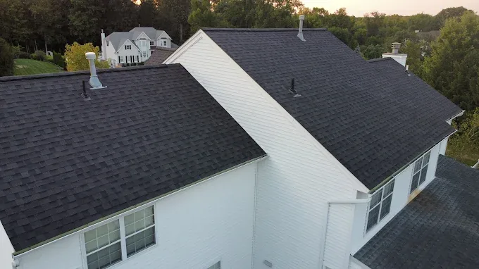 Close aerial inspection view of a shingle roof, vents and pipe boots