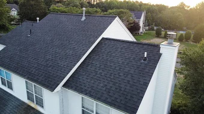 Finished architectural shingle roof on a white two-storey home