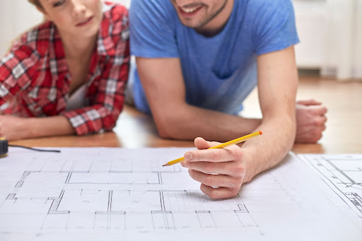 man and woman looking at blueprints