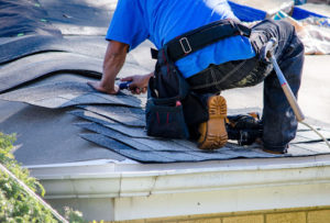 Roof installer stapling shingles to a new installation