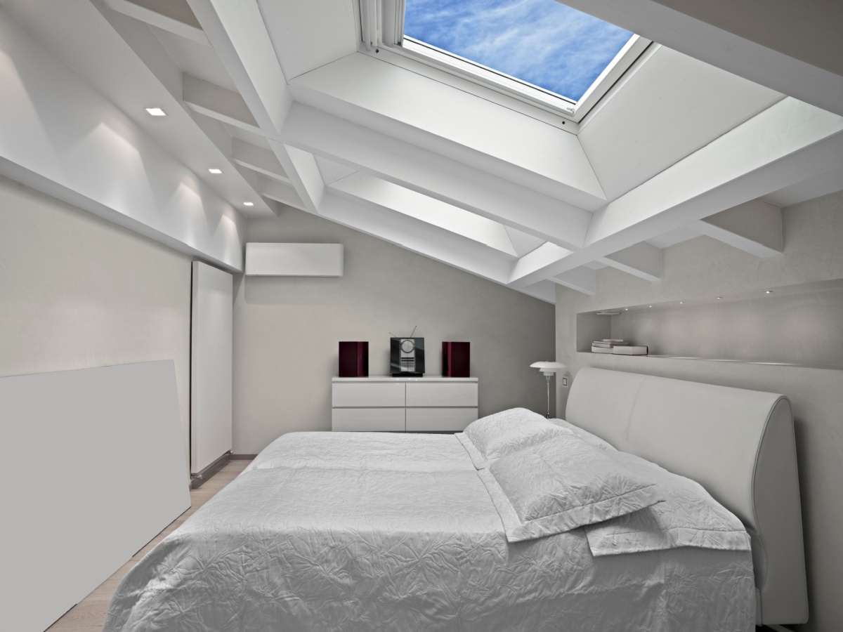 New skylights over a bed with a white comforter and pillows